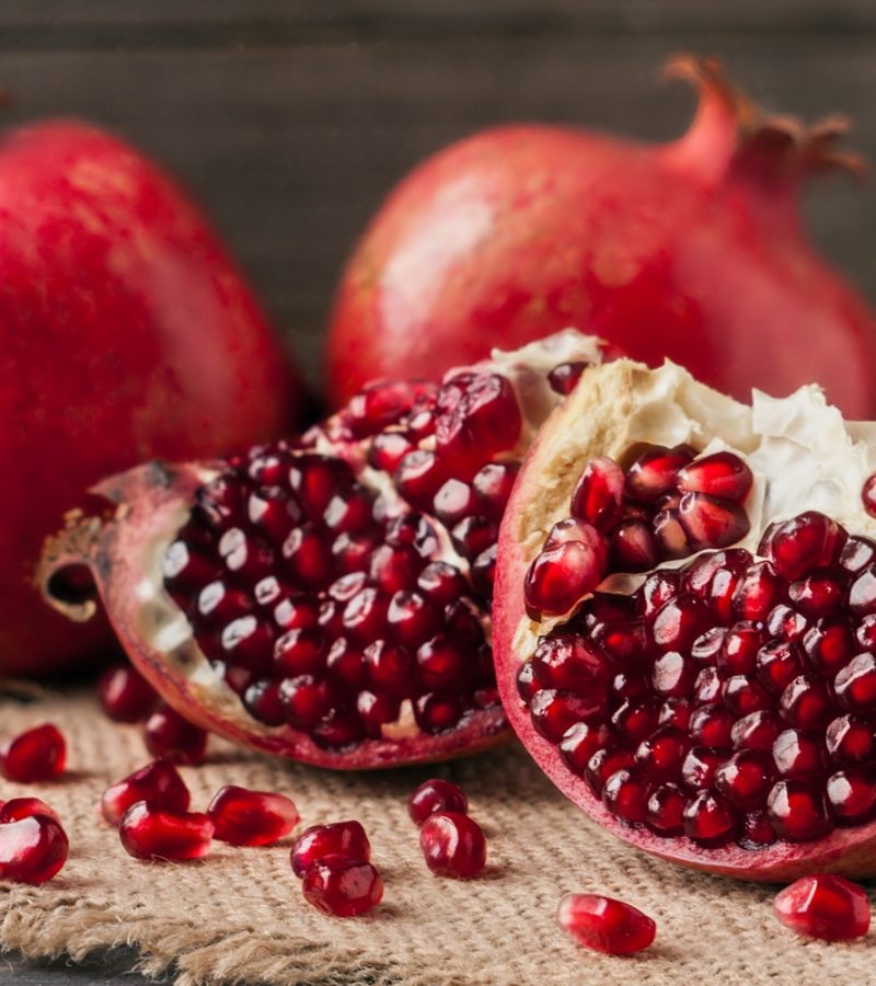 two pomegranate on the old wooden board with sackcloth.